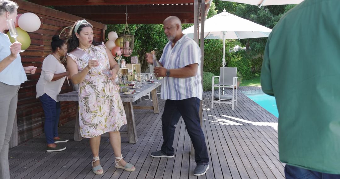 Joyful Senior Friends Toasting and Dancing at Poolside Party