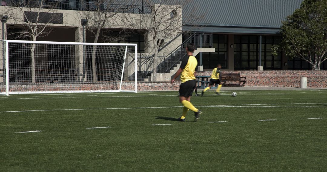 Soccer Players in Yellow Jerseys Practicing on Green Field