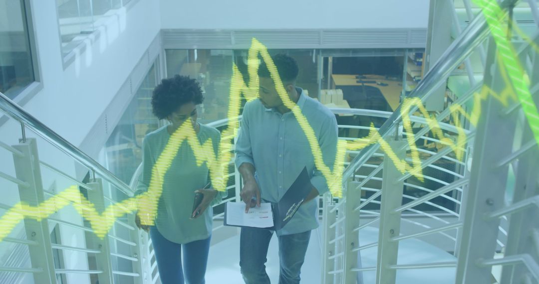 Colleagues Analyzing Financial Graphs in Modern Office Environment