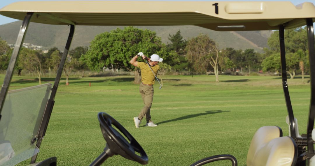 Golf cart over aucasian male golf player playing golf at golf course - Free Images, Stock Photos and Pictures on Pikwizard.com