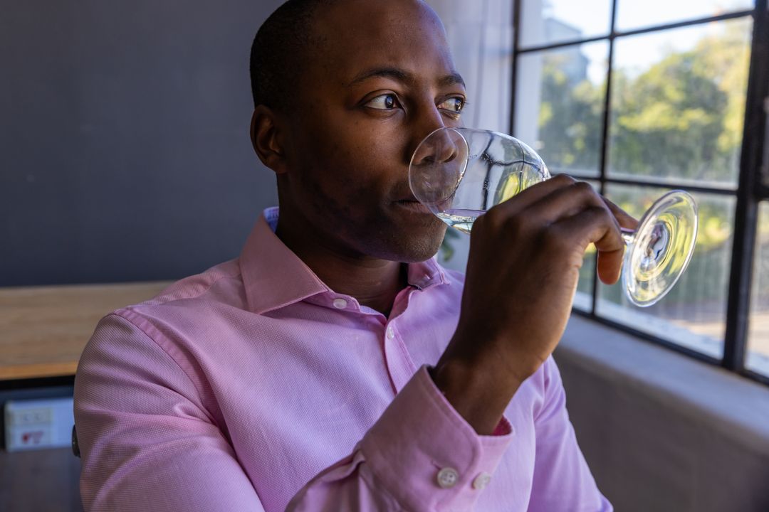 Sophisticated Man Enjoying Wine at Café in Urban Setting