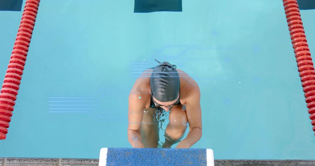 Female swimmer preparing on starting block in competition pool with red lane ropes