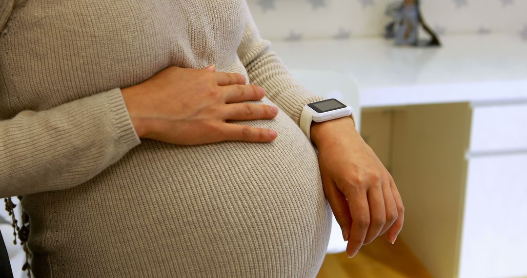 Pregnant Woman with Smartwatch Holding Her Belly - Free Images, Stock Photos and Pictures on Pikwizard.com