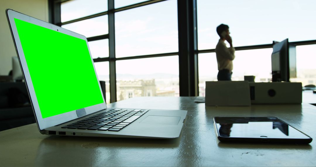 Laptop with Green Screen on Desk in Modern Office Environment - Free Images, Stock Photos and Pictures on Pikwizard.com