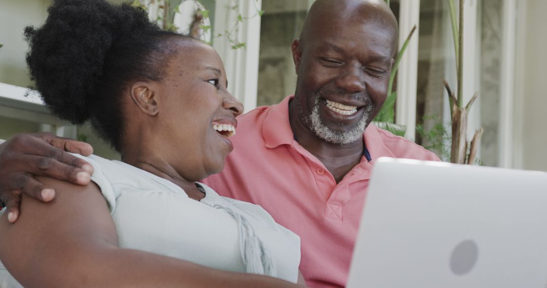 Happy Senior African American Couple Using Laptop at Home