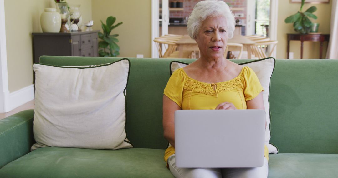 Senior Woman Using Laptop at Home on Green Couch - Free Images, Stock Photos and Pictures on Pikwizard.com