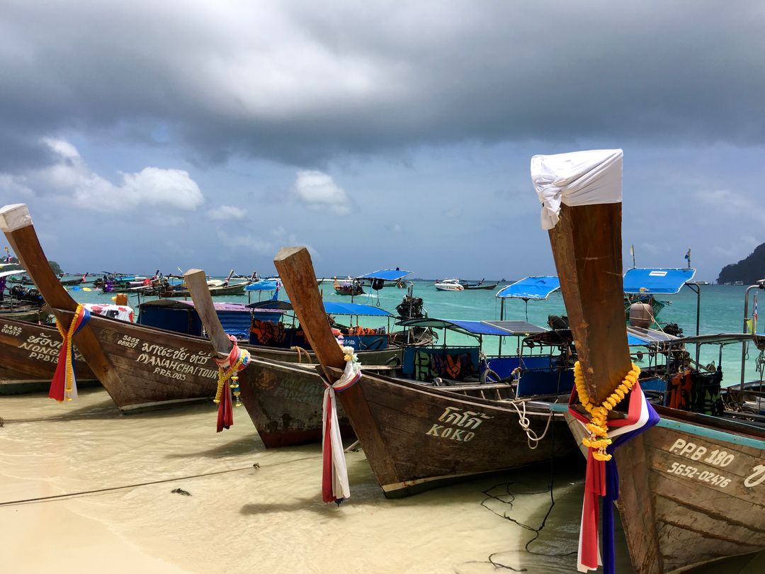 Traditional Thai Longtail Boats Docked on Tropical Shoreline - Free Images, Stock Photos and Pictures on Pikwizard.com