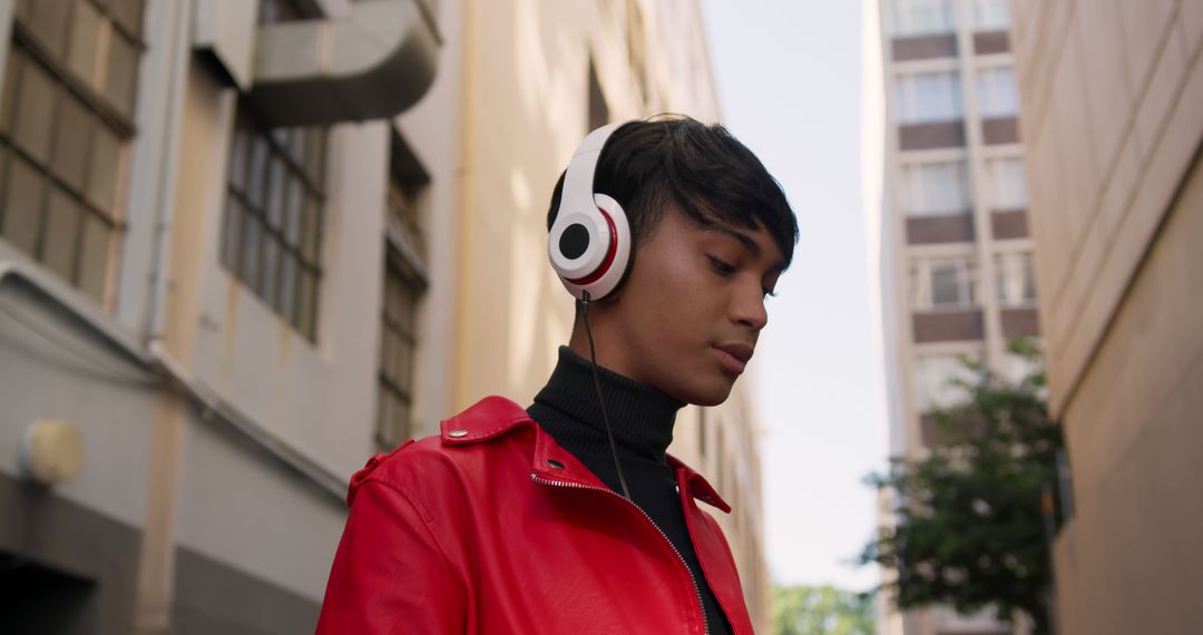 Young Man with Headphones Wearing Red Jacket in Urban Alleyway - Free Images, Stock Photos and Pictures on Pikwizard.com