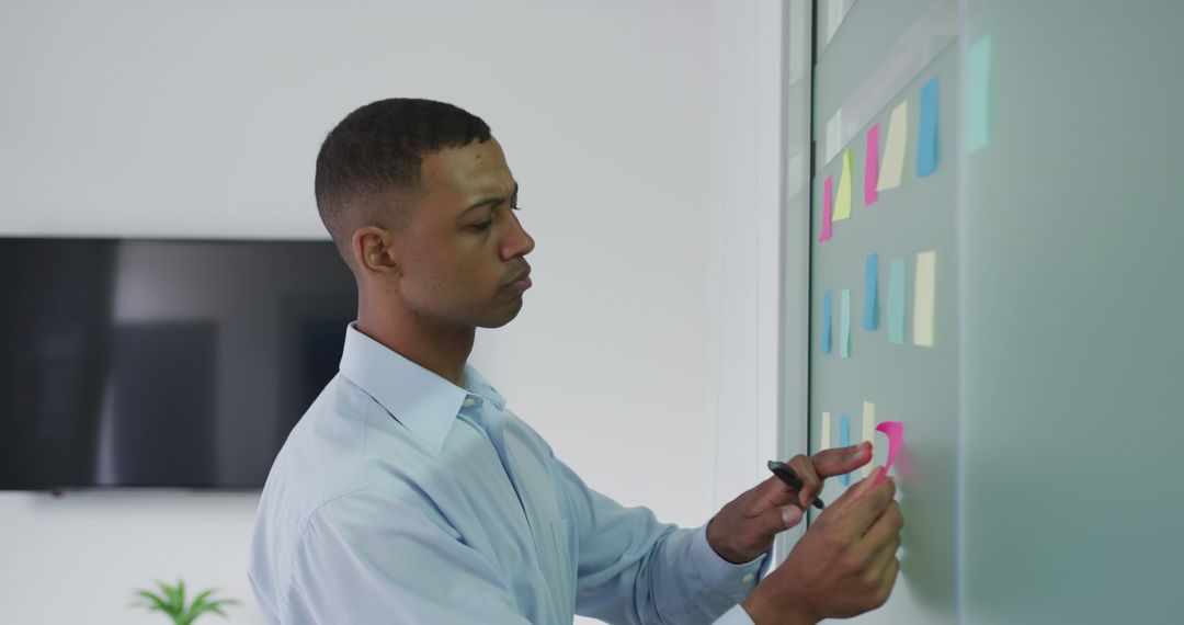 Focused Businessman Planning on Office Whiteboard with Sticky Notes - Free Images, Stock Photos and Pictures on Pikwizard.com