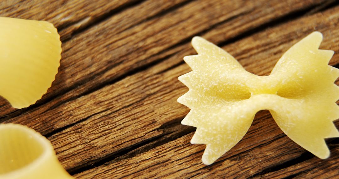 Close-Up of Raw Bowtie and Shell Pasta on Rustic Wooden Surface - Free Images, Stock Photos and Pictures on Pikwizard.com