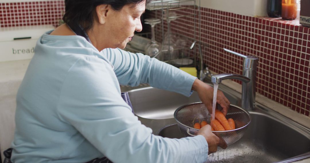 Senior Woman Washing Carrots in Kitchen Sink - Free Images, Stock Photos and Pictures on Pikwizard.com