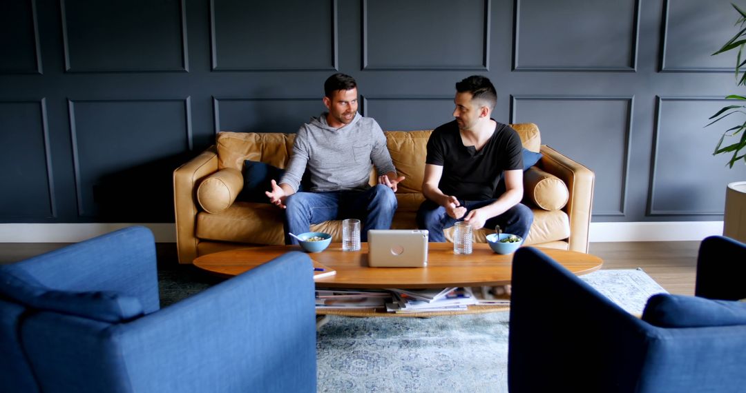 Two Men Engaging in Friendly Conversation in Modern Living Room - Free Images, Stock Photos and Pictures on Pikwizard.com