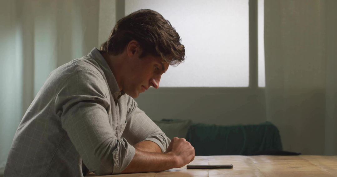 Man Focusing on Smartphone in Calming Living Room Setting