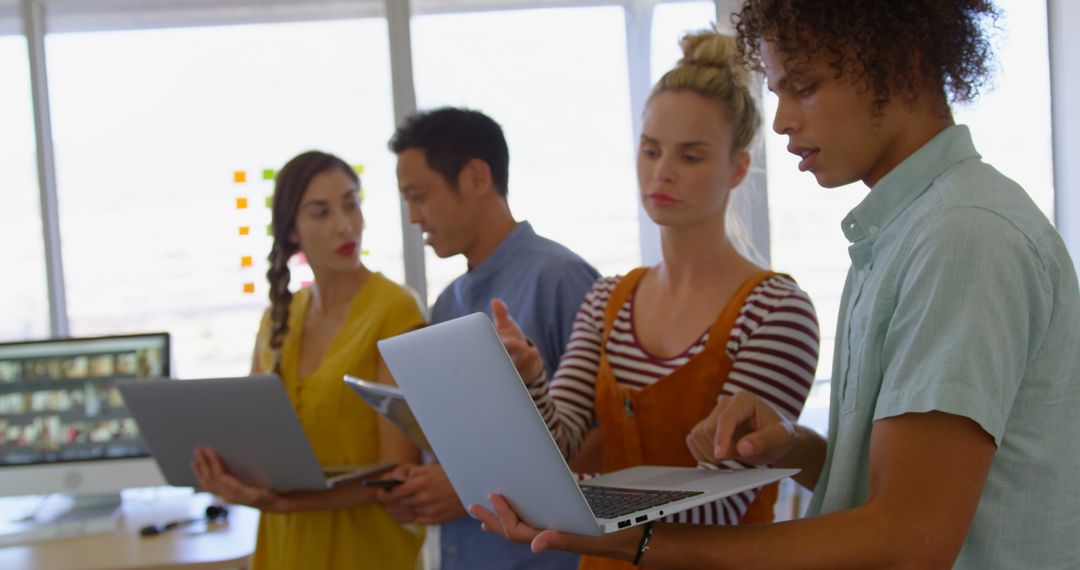 Diverse Team Collaborating in Modern Office with Tech Resources