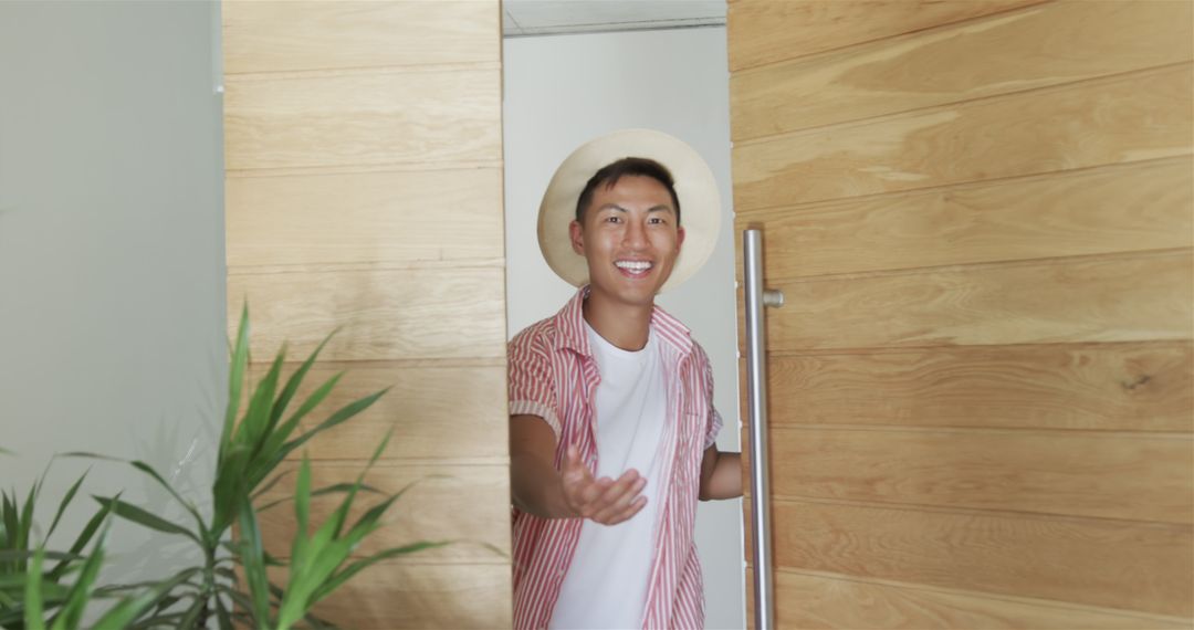 Young Man Entering Room Smiling Warmly Welcomed