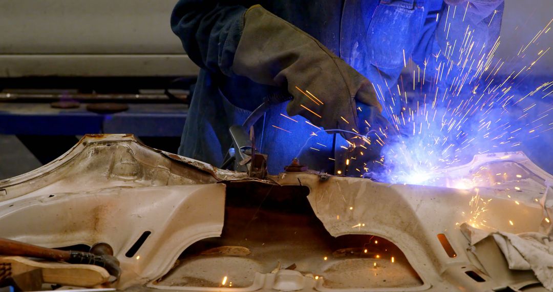 Welder Repairing Car Door Panel with Blue Sparks Flying - Free Images, Stock Photos and Pictures on Pikwizard.com