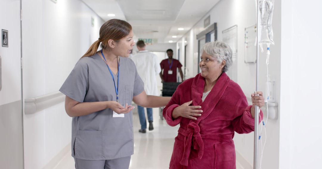 Nurse Attending to Senior Female Patient in Hospital Hallway - Free Images, Stock Photos and Pictures on Pikwizard.com