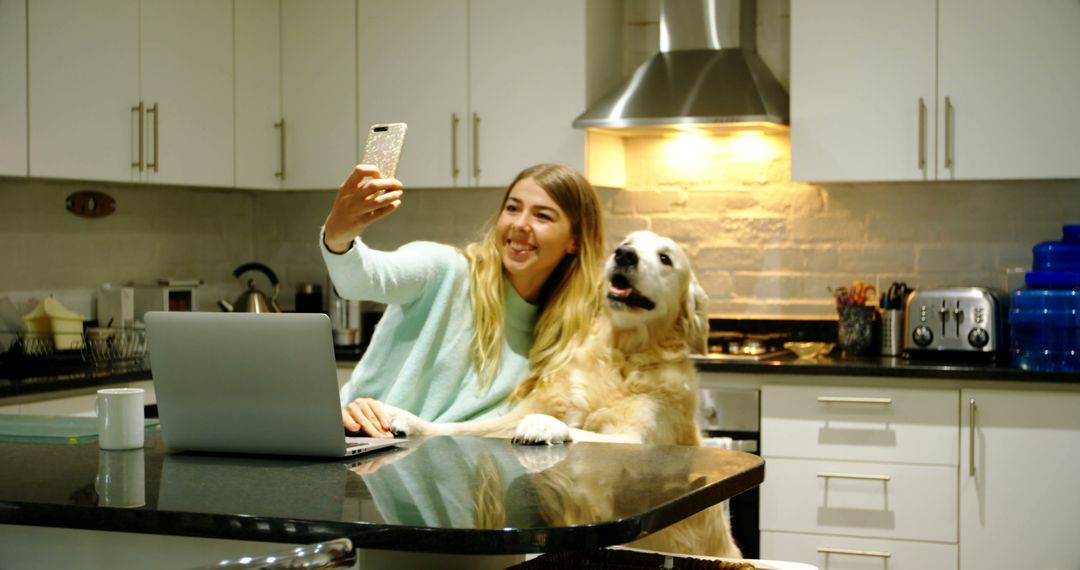 Young Woman Taking Selfie with Dog in Modern Kitchen - Free Images, Stock Photos and Pictures on Pikwizard.com