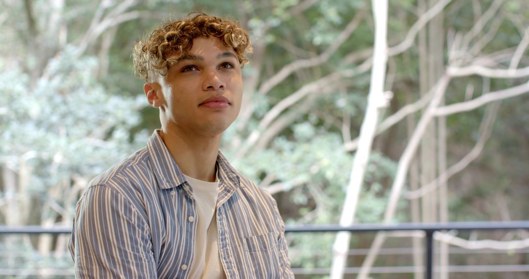 Young Man Contemplating Scenic View Through Large Windows