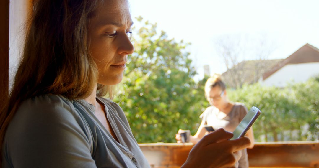 Woman Reading Smartphone Enters Focus, Outdoors Daytime Setting - Free Images, Stock Photos and Pictures on Pikwizard.com