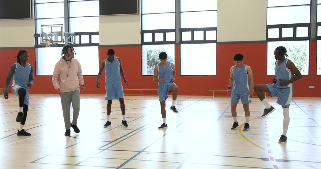 Dedicated Coach Leading Athletic Team in Dynamic Warm-Up Drill