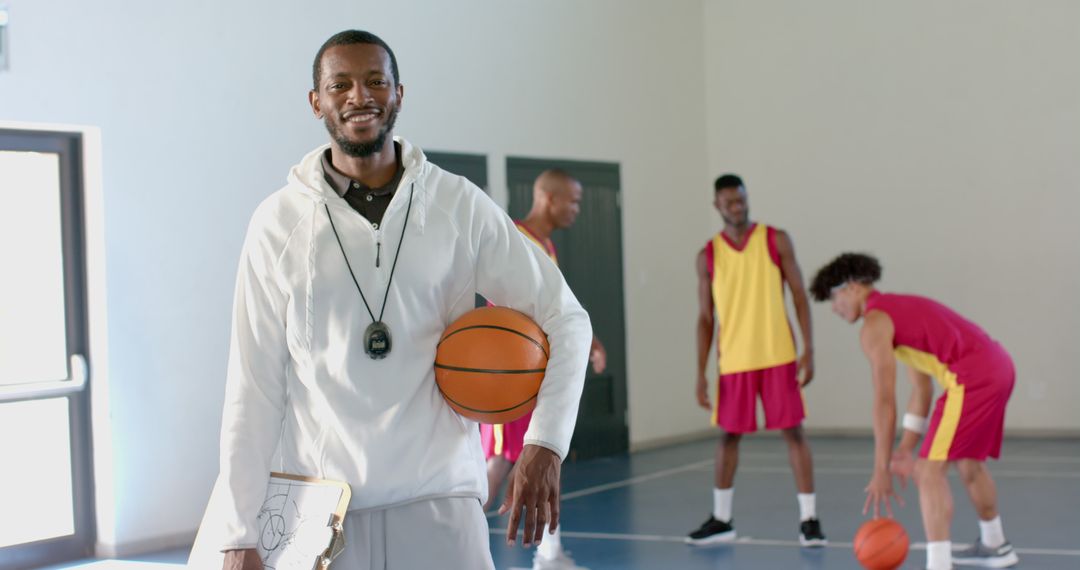 Basketball Coach Overseeing Players During Training Session in Gym