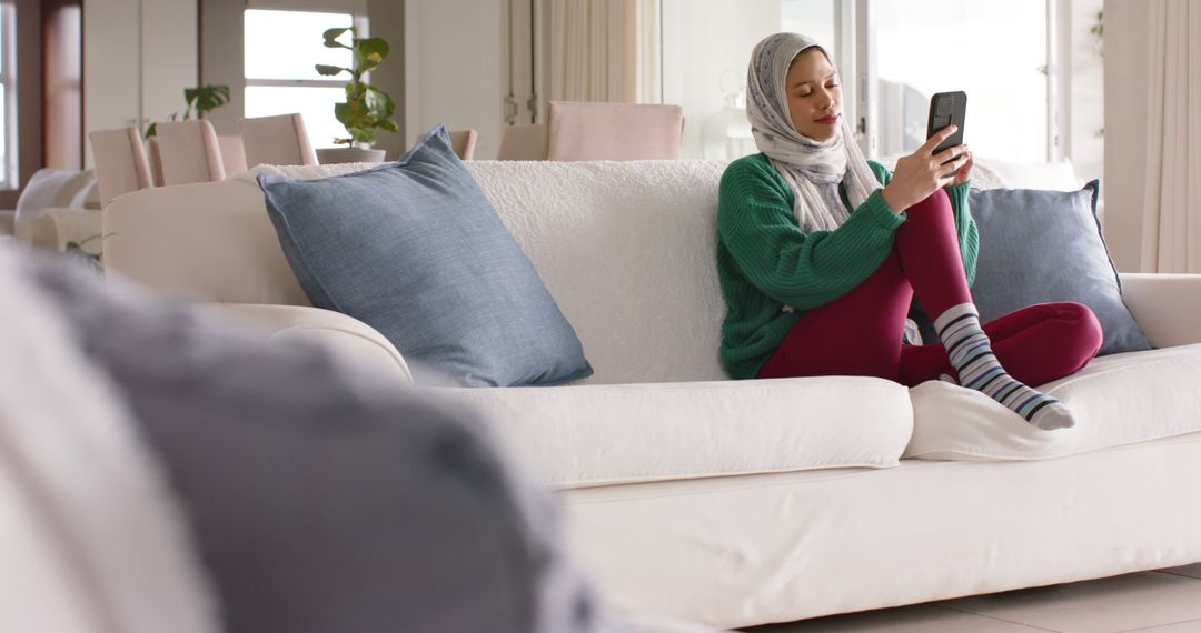 Woman Relaxing on Couch at Home, Using Smartphone - Free Images, Stock Photos and Pictures on Pikwizard.com