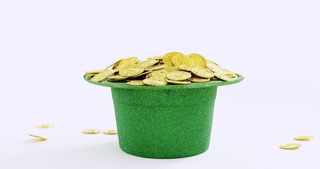 Green Glitter Hat Filled with Gold Coins on Plain Background - Free Images, Stock Photos and Pictures on Pikwizard.com