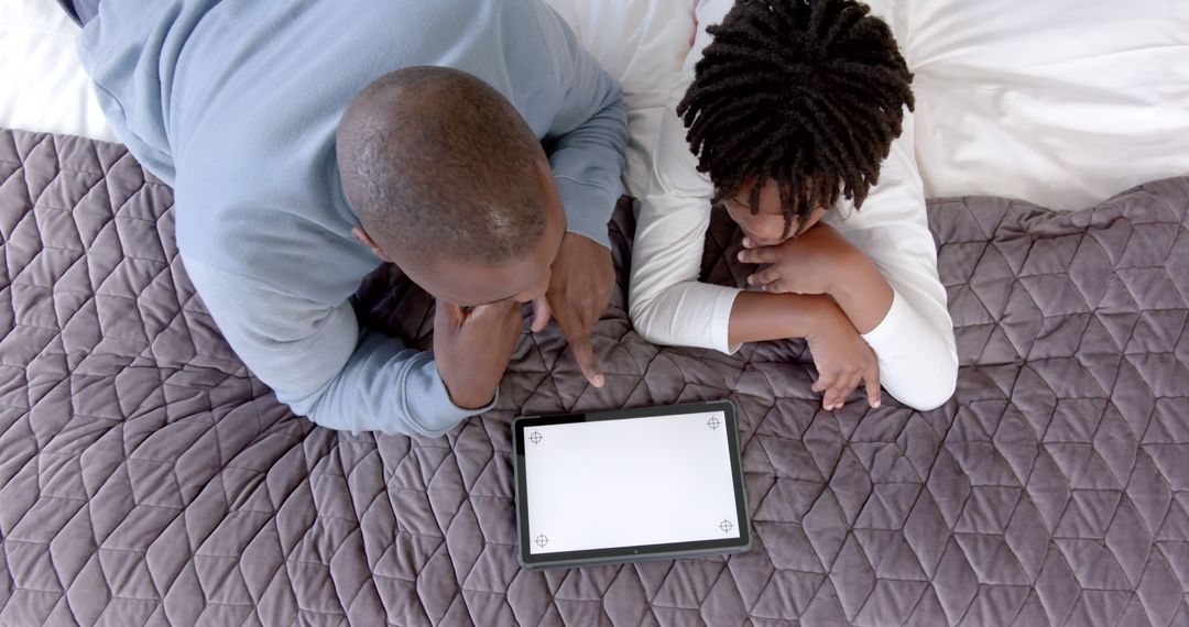 Father And Daughter Watching Tablet On Bed - Free Images, Stock Photos and Pictures on Pikwizard.com