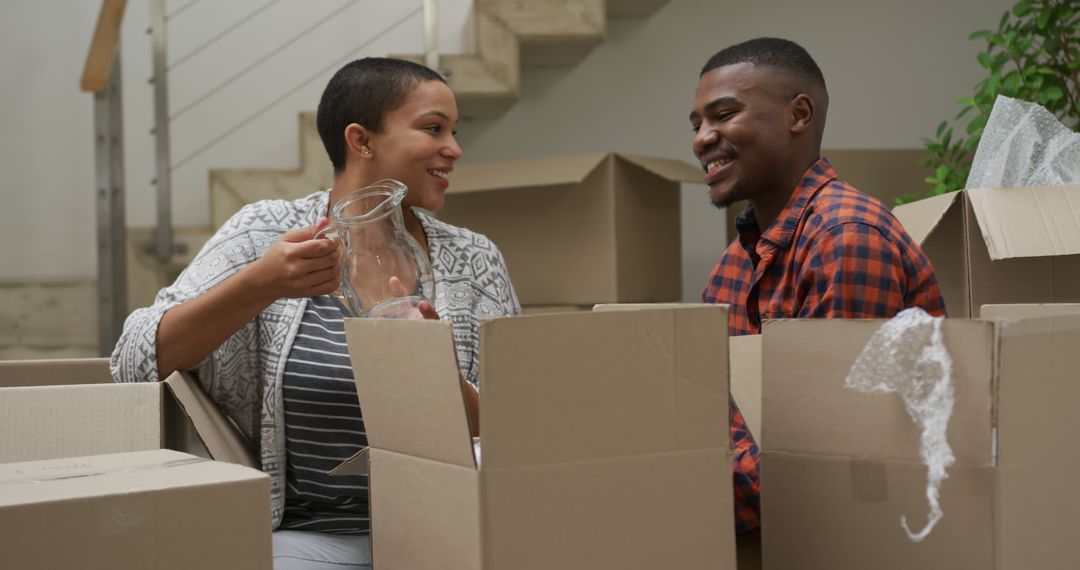 Happy Couple Unpacking Boxes During New Home Move
