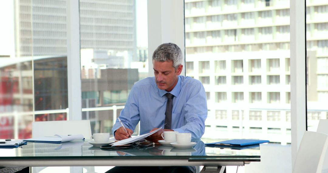 Businessman working at modern office table with documents and coffee - Free Images, Stock Photos and Pictures on Pikwizard.com