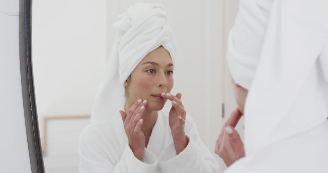 Woman Applying Lip Balm in Bathroom Mirror with White Towel Wrap - Free Images, Stock Photos and Pictures on Pikwizard.com