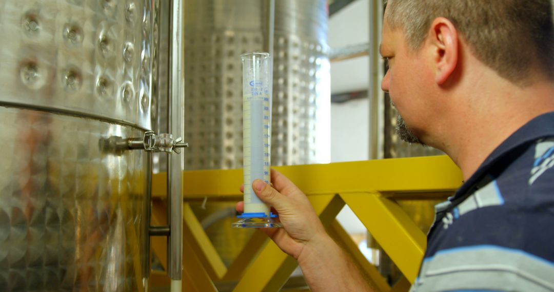 Brewery Worker Inspecting Fermentation Process in Stainless Steel Tank - Free Images, Stock Photos and Pictures on Pikwizard.com