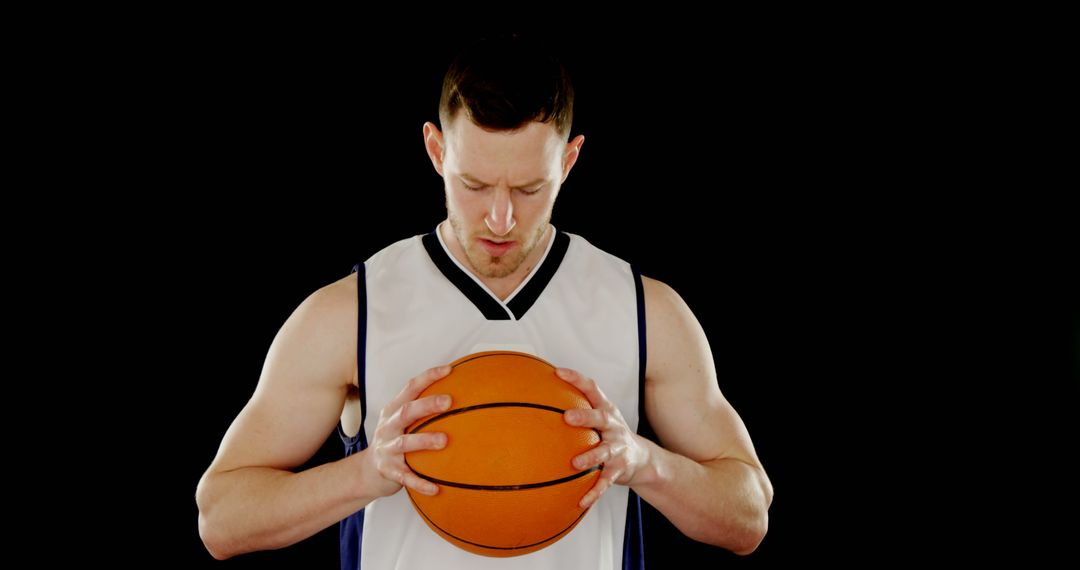 Focused basketball player holding ball on dark background - Free Images, Stock Photos and Pictures on Pikwizard.com