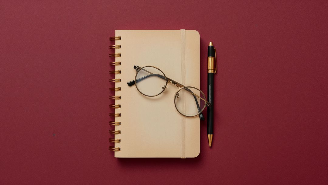Notebook with Glasses and Pen on Red Background
