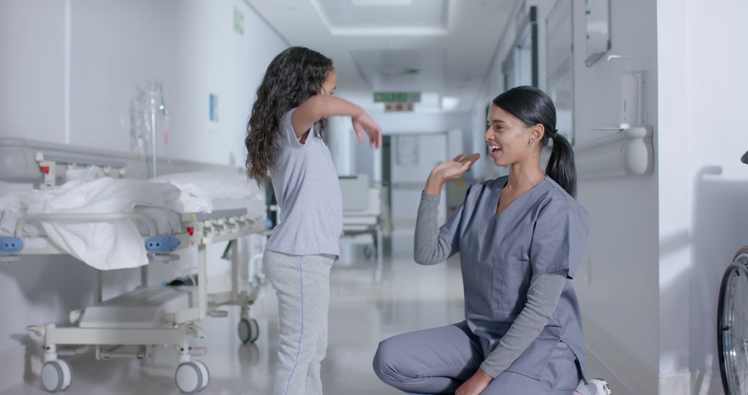 Nurse Communicating with Young Patient Using Sign Language in Hospital Corridor - Free Images, Stock Photos and Pictures on Pikwizard.com