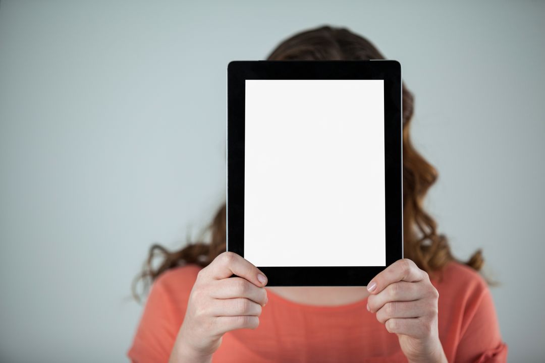 Woman holding a digital tablet in front of her face - Free Images, Stock Photos and Pictures on Pikwizard.com