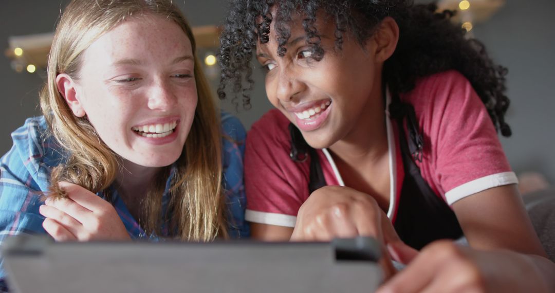 Diverse teenage girls smiling while using digital tablet - Free Images, Stock Photos and Pictures on Pikwizard.com