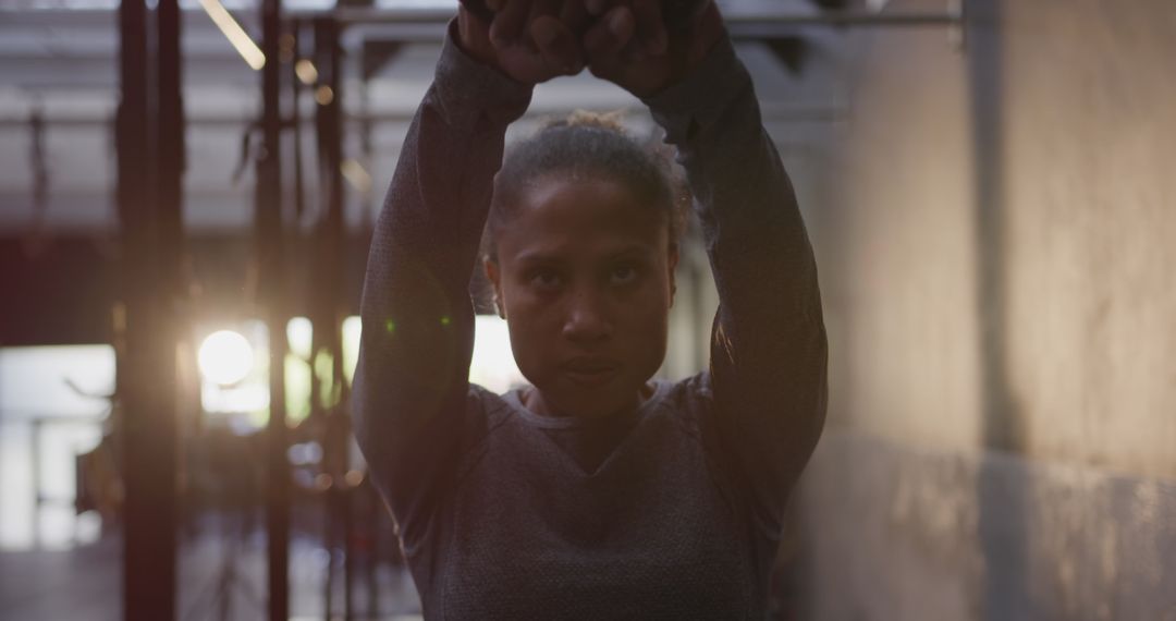 Determined Female Athlete Performing Kettlebell Exercise in Gym