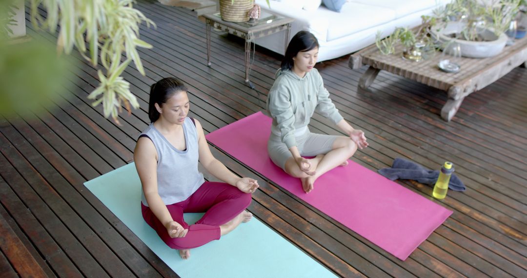 Two Women Meditating on Yoga Mats in Cozy Wooden Terrace - Free Images, Stock Photos and Pictures on Pikwizard.com