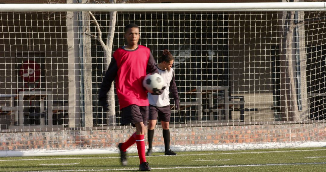 Soccer Players Training on Field With Goal Nets