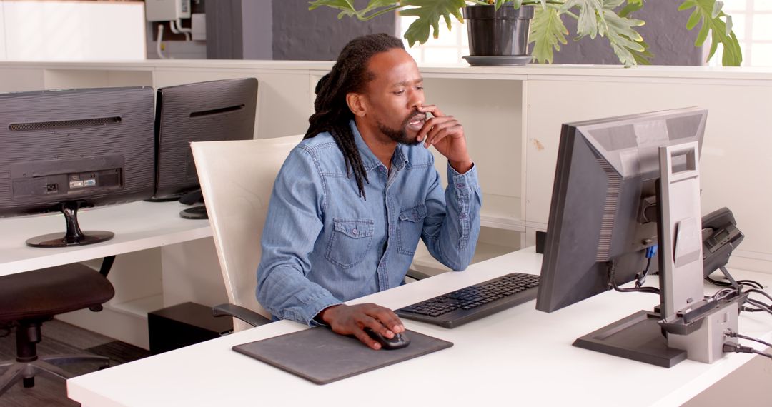 Focused Professional in Modern Office Using Computer Technology