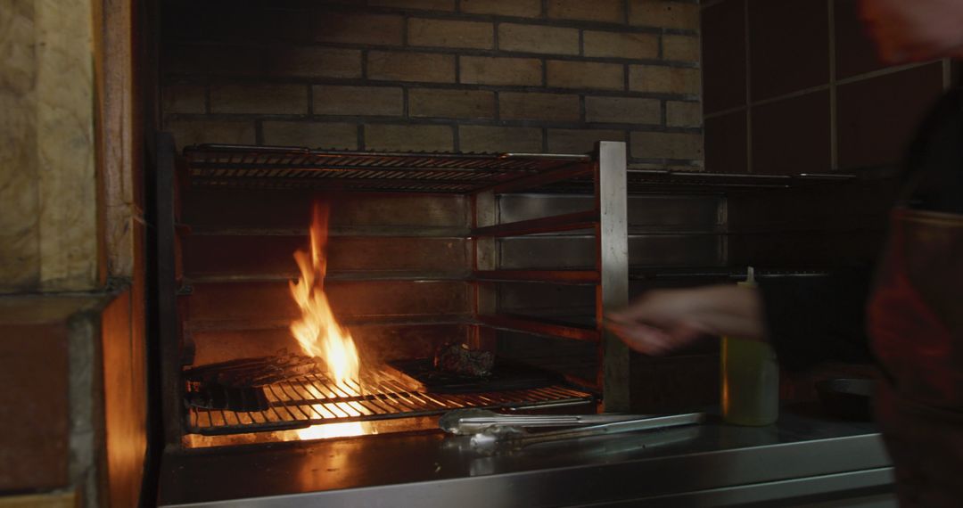 Chef Grilling Meat Over Open Flame in Kitchen - Free Images, Stock Photos and Pictures on Pikwizard.com