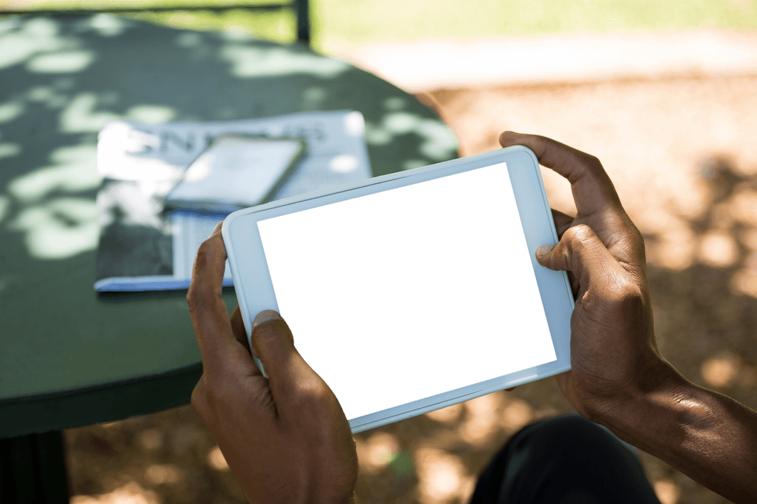 Person Using Transparent Tablet at Outdoor Cafe Table