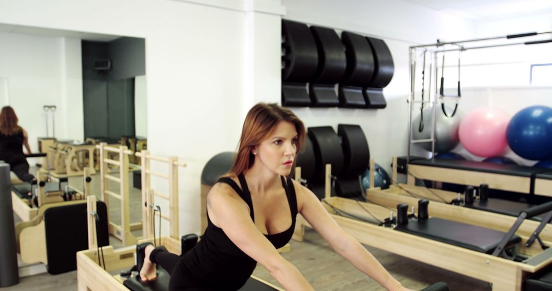 Woman practicing pilates inside studio using reformer machine - Free Images, Stock Photos and Pictures on Pikwizard.com