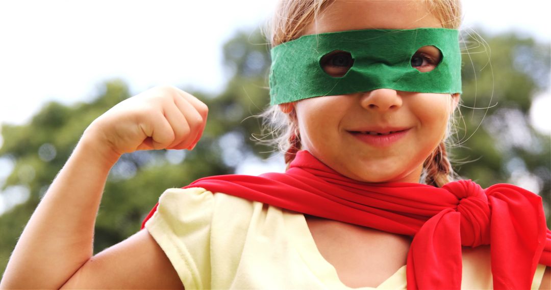 Young Girl Dressed as Superhero Flexing Muscles Outdoors - Free Images, Stock Photos and Pictures on Pikwizard.com