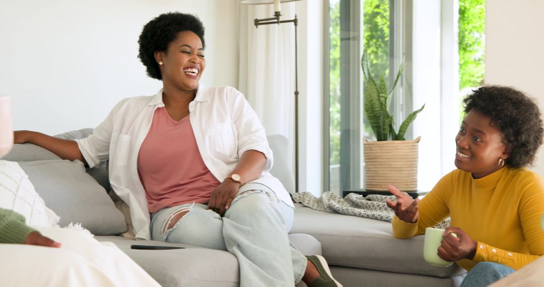 Friends Engaged in Lively Conversation on Sofa Together at Home