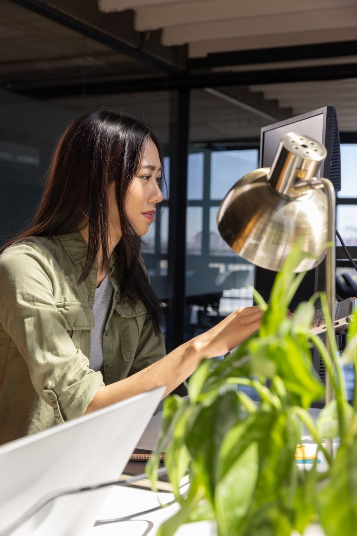 Professional Woman Focused on Work in Modern Open Office Space