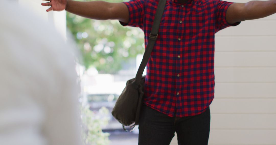 Young Man Greeting with Open Arms in Checkered Shirt - Free Images, Stock Photos and Pictures on Pikwizard.com