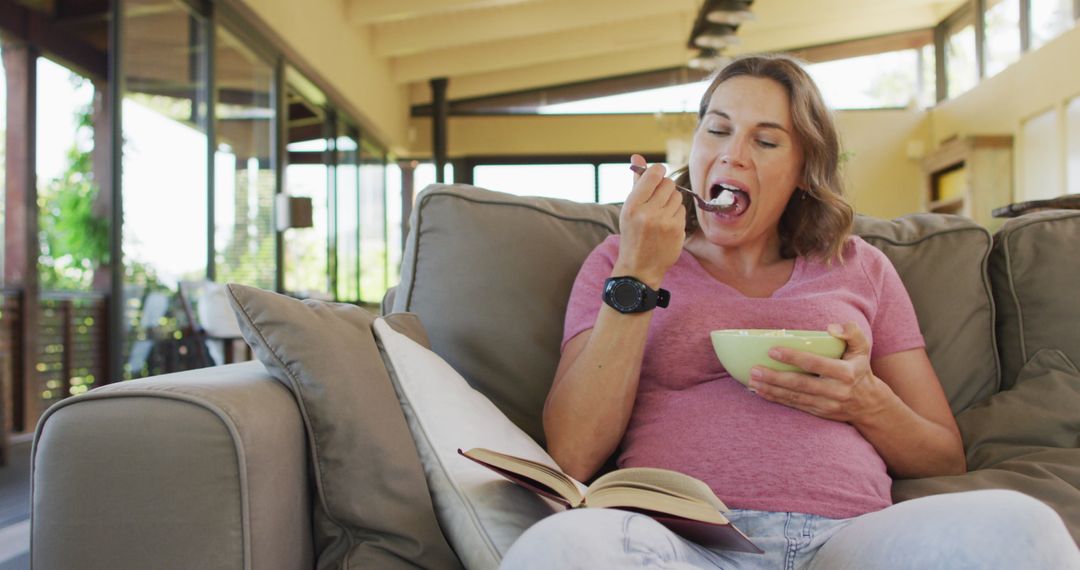 Pregnant Woman Relaxing with Book and Snack at Home